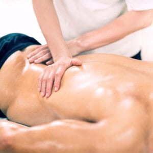 Mężczyzna leżący na kozetce spa podczas masażu sportowego